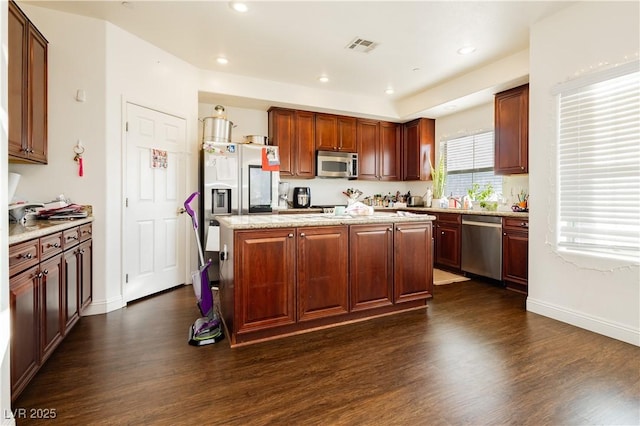 kitchen featuring dark wood finished floors, a kitchen island, and stainless steel appliances