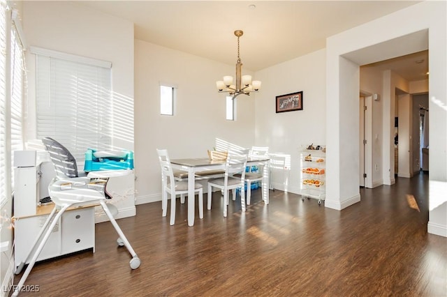 dining space with a notable chandelier, wood finished floors, and baseboards