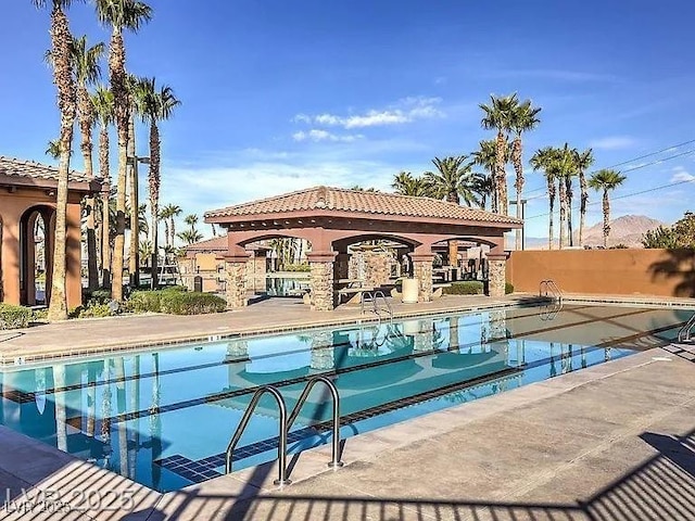 community pool with a patio and fence