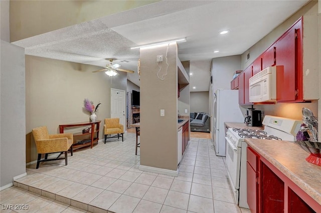 kitchen featuring white appliances, light tile patterned flooring, red cabinets, and a ceiling fan