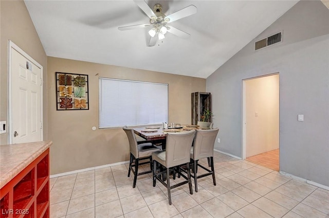 dining space featuring visible vents, a ceiling fan, light tile patterned flooring, vaulted ceiling, and baseboards