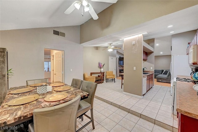 dining area featuring light tile patterned floors, ceiling fan, visible vents, and high vaulted ceiling