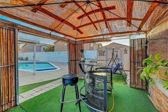 view of swimming pool with a fenced backyard, an outbuilding, a storage unit, a gazebo, and a patio area