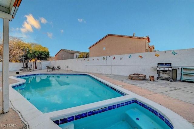 view of pool with a fenced in pool, a patio, a grill, an in ground hot tub, and a fenced backyard