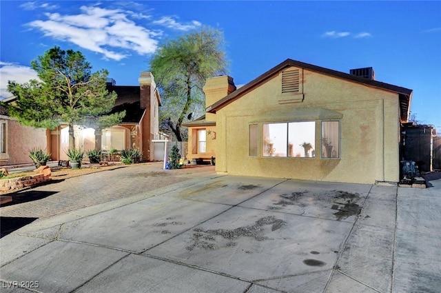 back of house featuring central AC, a patio area, fence, and stucco siding