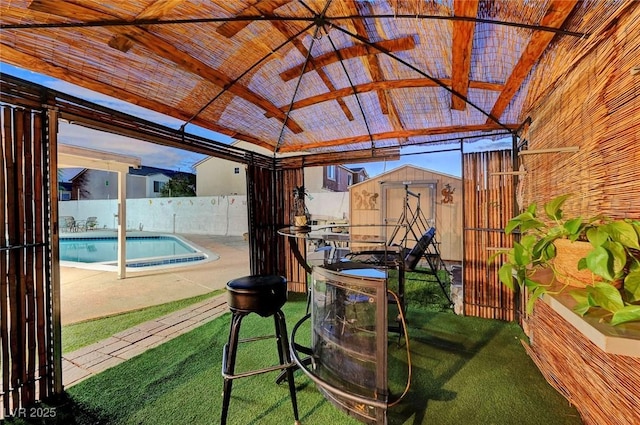 exterior space with a fenced in pool, a storage unit, a gazebo, a fenced backyard, and an outdoor structure