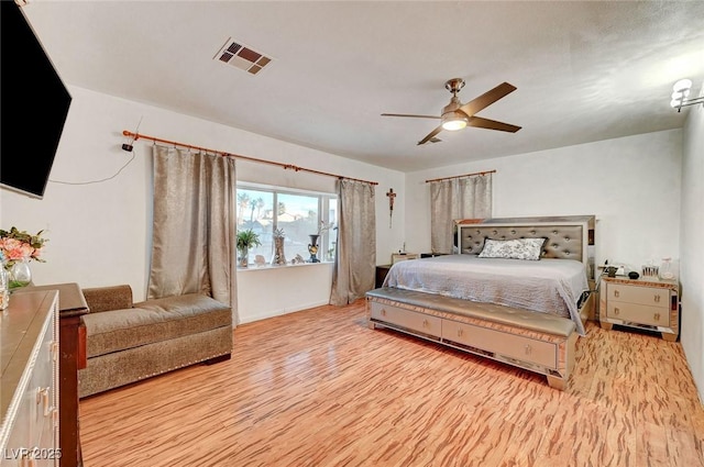 bedroom with light wood finished floors, visible vents, and a ceiling fan