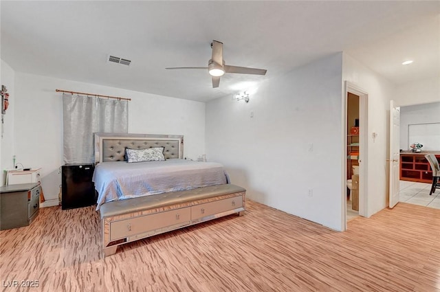 bedroom with a ceiling fan, visible vents, and wood finished floors