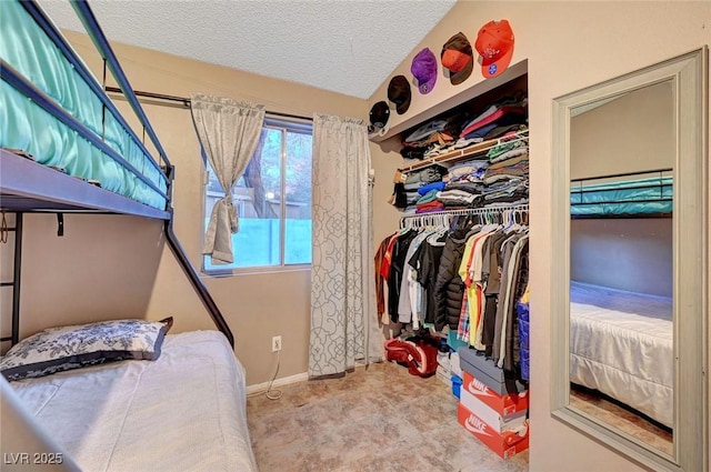 bedroom with a textured ceiling, a closet, and baseboards