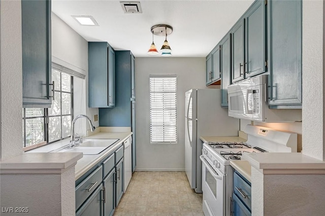 kitchen with white appliances, plenty of natural light, visible vents, light countertops, and a sink