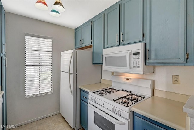 kitchen featuring light countertops, white appliances, blue cabinetry, and baseboards