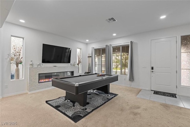 game room featuring recessed lighting, light carpet, a glass covered fireplace, and visible vents