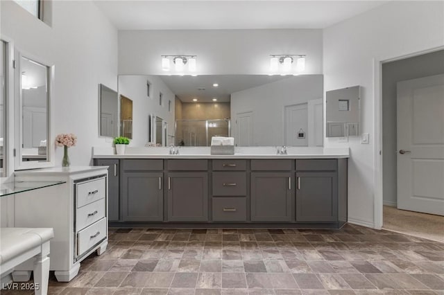 bathroom featuring a sink, a shower stall, and double vanity