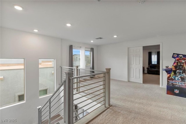 hallway featuring recessed lighting, light carpet, visible vents, baseboards, and an upstairs landing