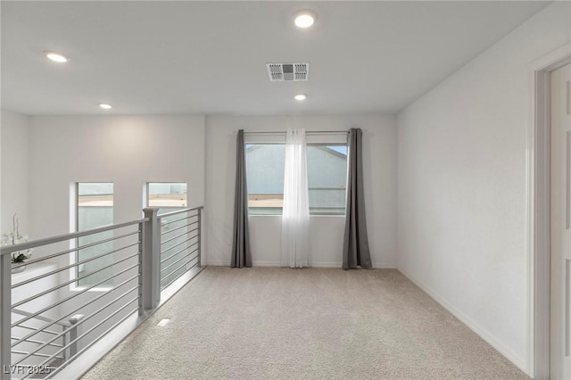 empty room featuring light carpet, baseboards, visible vents, and recessed lighting