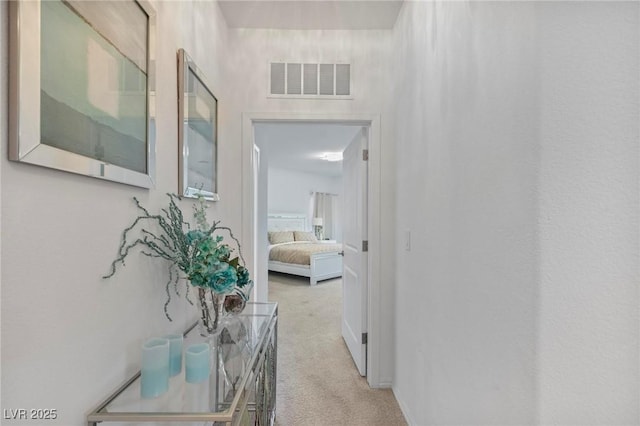 hallway with light carpet and visible vents