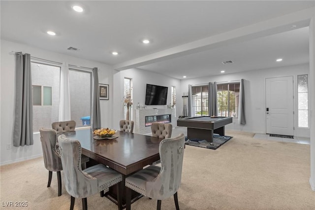 dining area featuring light carpet, a glass covered fireplace, visible vents, and recessed lighting