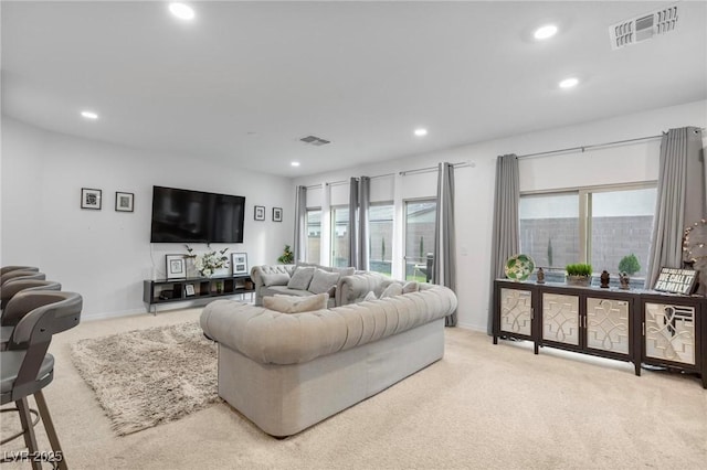 living area featuring light colored carpet, visible vents, and recessed lighting