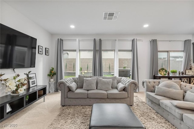 living area with recessed lighting, visible vents, and light colored carpet