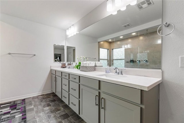 bathroom with visible vents, a sink, baseboards, and double vanity