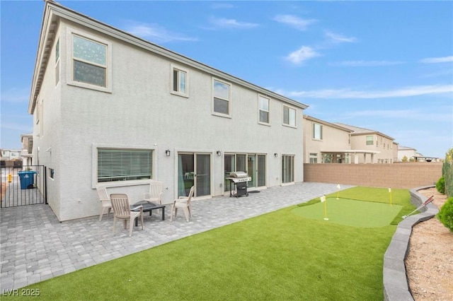 back of house featuring a patio area, fence, a residential view, and stucco siding