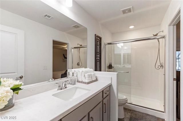 ensuite bathroom featuring visible vents, toilet, vanity, and ensuite bath