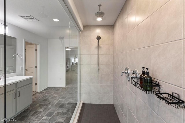 full bathroom with a walk in shower, vanity, and visible vents