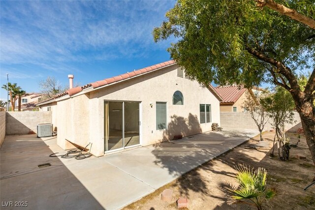 back of property featuring a fenced backyard, a tiled roof, central air condition unit, a patio area, and stucco siding