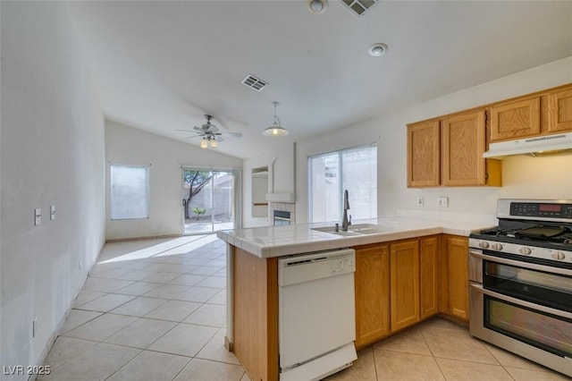 kitchen with under cabinet range hood, a sink, visible vents, double oven range, and dishwasher