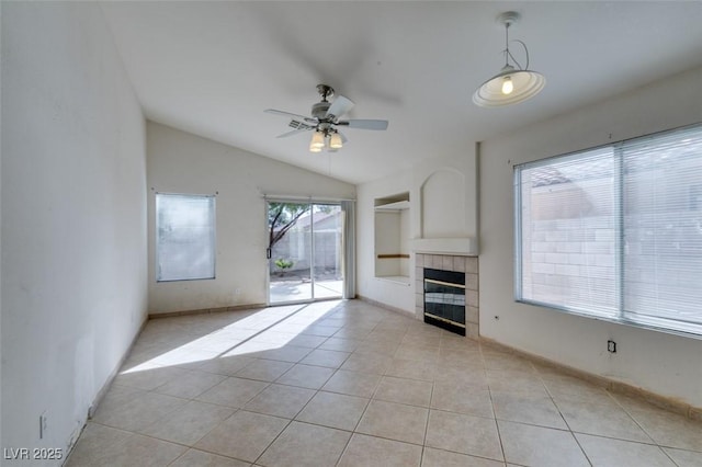 unfurnished living room with ceiling fan, lofted ceiling, light tile patterned flooring, baseboards, and a tiled fireplace