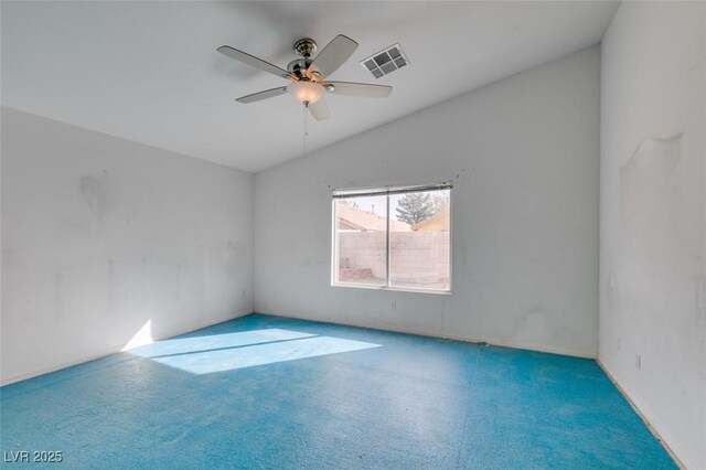 carpeted spare room with visible vents, vaulted ceiling, and a ceiling fan