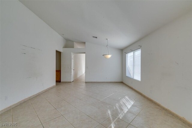 unfurnished room featuring lofted ceiling, light tile patterned floors, baseboards, and visible vents
