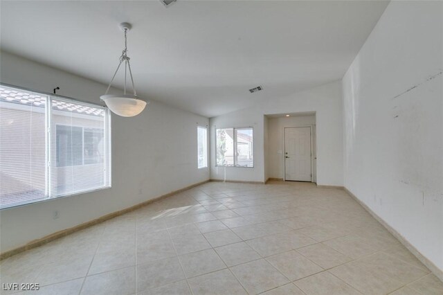 unfurnished room with light tile patterned floors, visible vents, baseboards, and vaulted ceiling