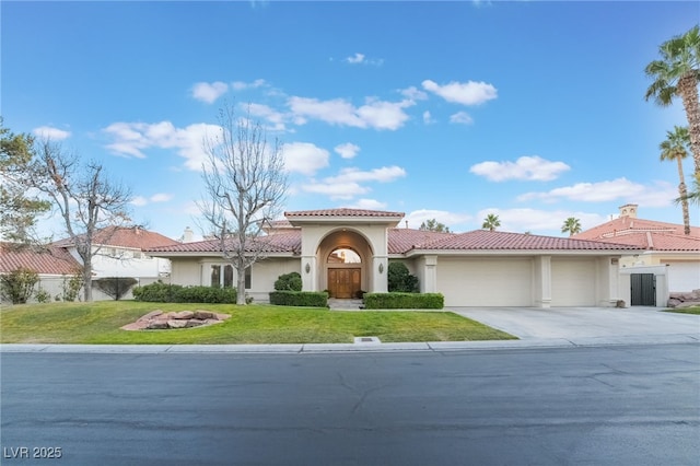 mediterranean / spanish-style house with a garage, driveway, stucco siding, a tile roof, and a front yard