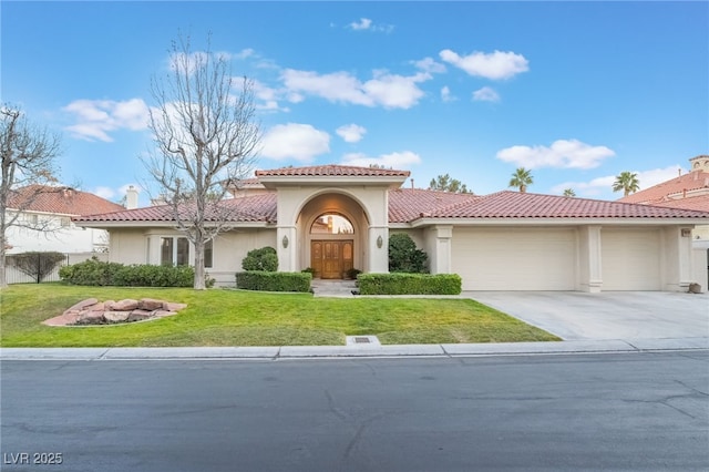 mediterranean / spanish home with a garage, concrete driveway, a tiled roof, and stucco siding