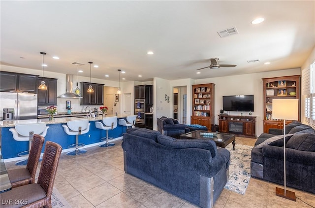 living room with light tile patterned floors, visible vents, a ceiling fan, and recessed lighting