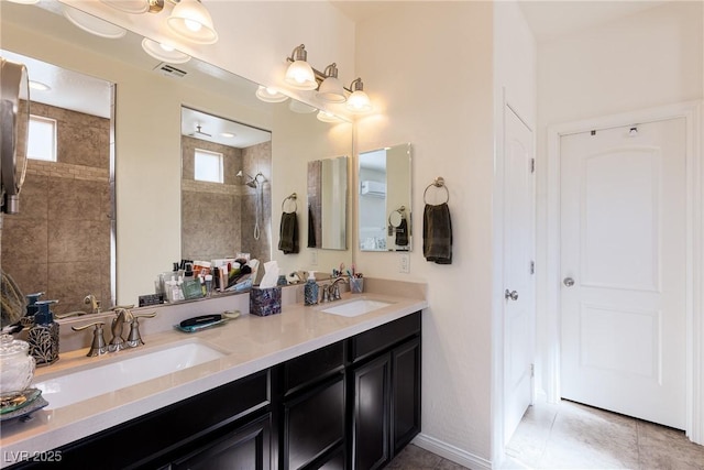 full bathroom featuring double vanity, visible vents, a sink, and tiled shower