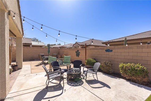 view of patio featuring an outdoor fire pit and a fenced backyard