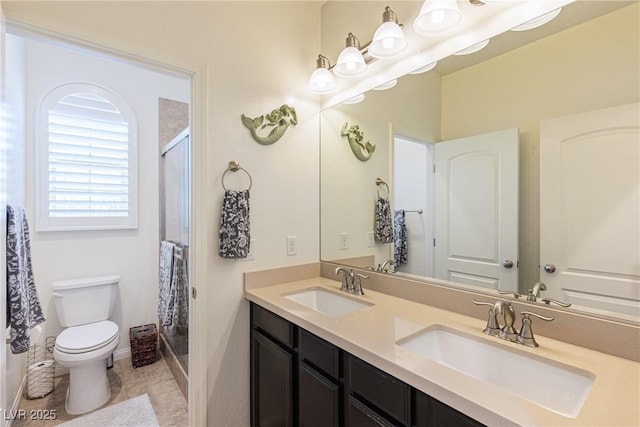 full bath with double vanity, a stall shower, a sink, and toilet