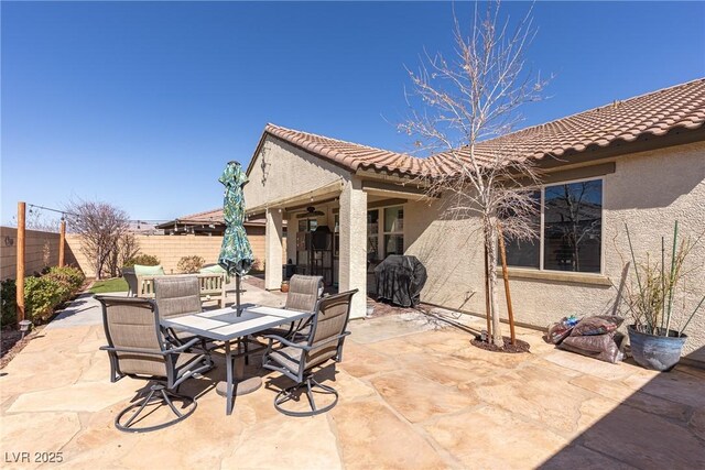 view of patio featuring a grill, fence, and outdoor dining area