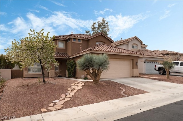 mediterranean / spanish home featuring a garage, concrete driveway, a tiled roof, and stucco siding