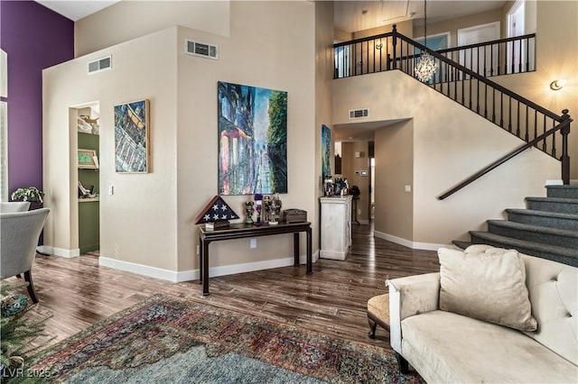 entrance foyer with wood finished floors, visible vents, and baseboards