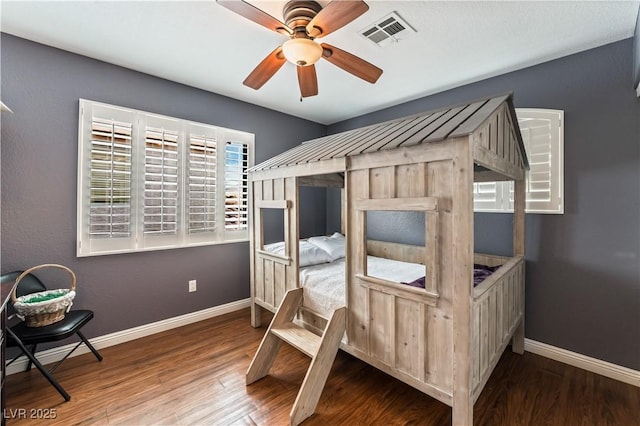 bedroom featuring wood finished floors, visible vents, and baseboards