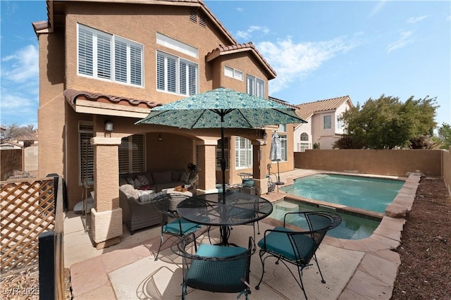 back of house with a patio, a fenced backyard, a tile roof, outdoor lounge area, and stucco siding