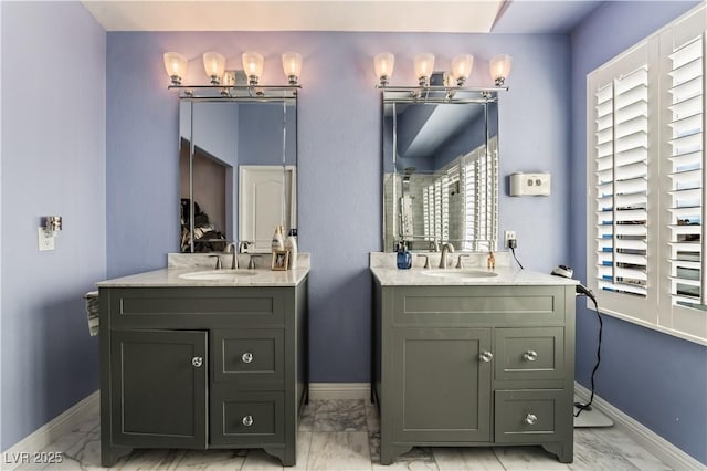 bathroom with a healthy amount of sunlight, marble finish floor, and a sink