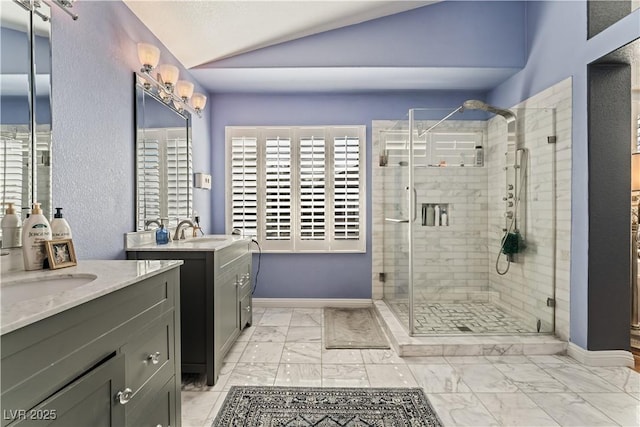 bathroom featuring lofted ceiling, marble finish floor, a shower stall, and baseboards