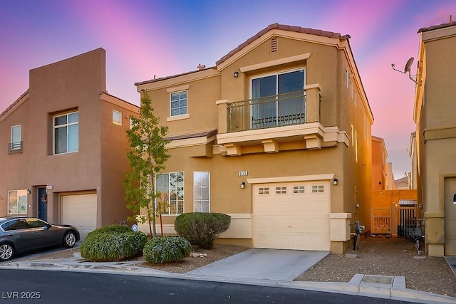 view of front of property featuring driveway, an attached garage, and stucco siding