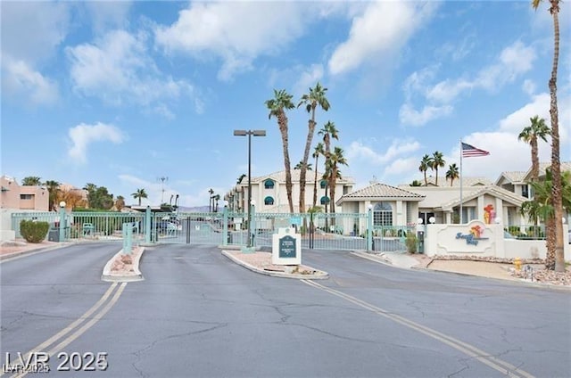 view of road featuring a residential view, a gate, curbs, and a gated entry