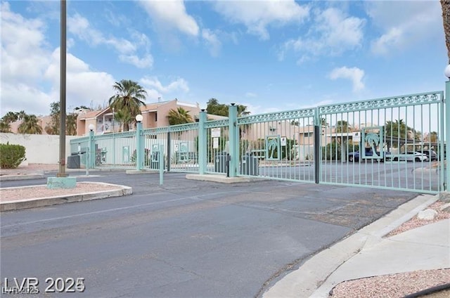 exterior space with curbs and a gated entry