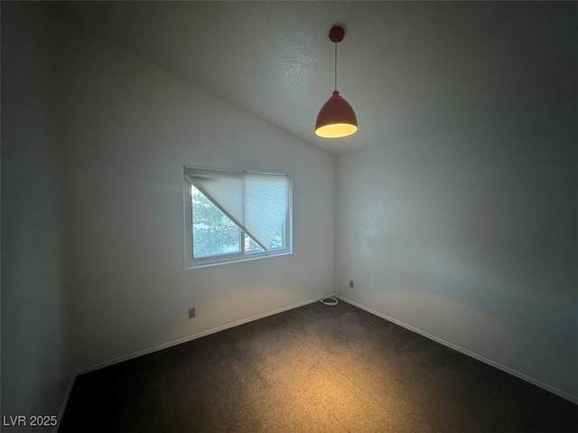 spare room with carpet, vaulted ceiling, and baseboards